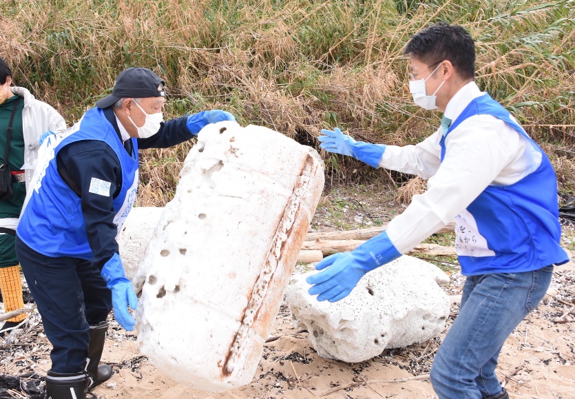 Photo of Yohei Sasakawa and Hidehiko Yuzaki participating in the beach cleanup