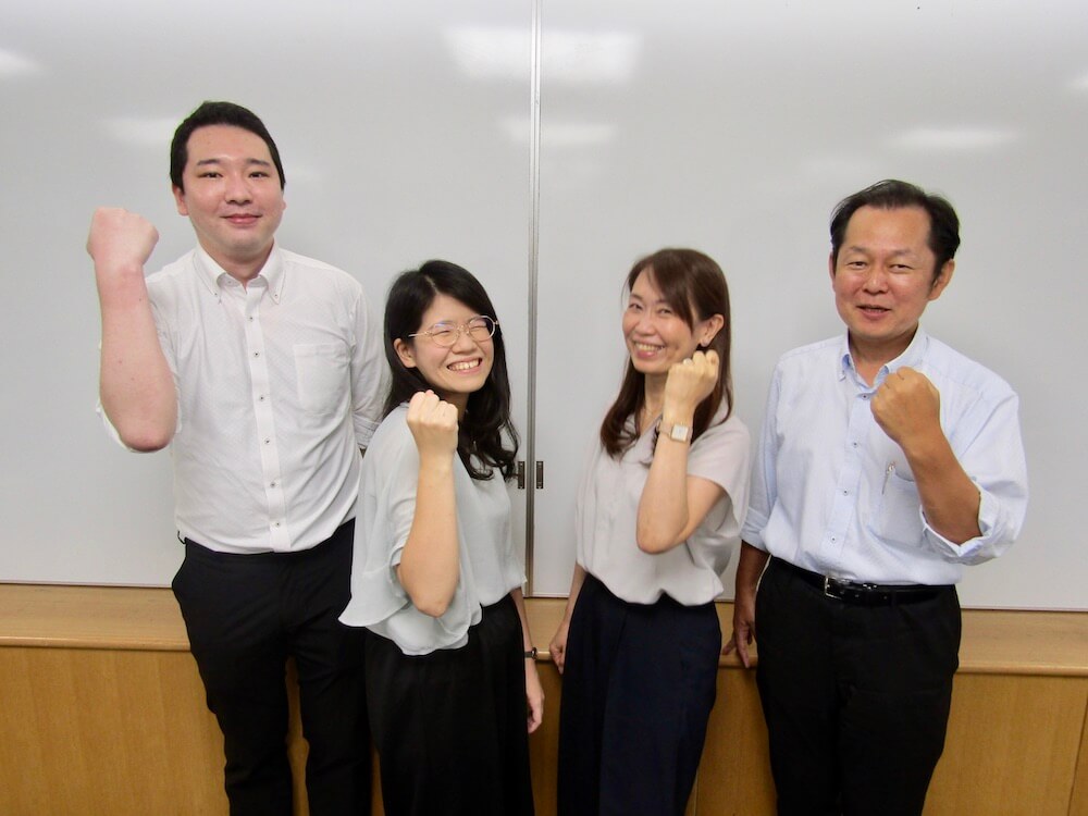 写真：ガッツポーズで笑顔を向ける今野さん、小関さん、山田さん、加藤さん