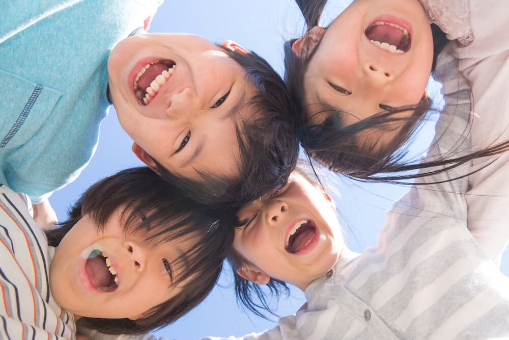 写真:円陣を組んで笑顔を向ける子どもたち