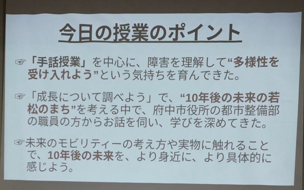 画像：
今日の授業のポイント
・「手話授業」を中心に、障害を理解して“多様性を受け入れよう”という気持ちを育んできた。
・「成長について調べよう」で、“10年後の未来の若松のまち”を考える中で、府中市役所の都市整備部の職員の方からお話を伺い、学びを深めてきた。
・未来のモビリティーの考え方や実物に触れることで、10年後の未来を、より身近に、より具体的に感じよう。