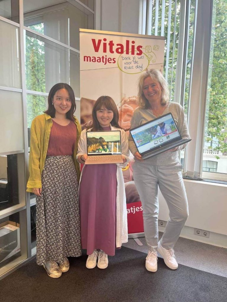 写真：Vitalis maatjesのメンバーと一緒に笑顔を向けるWe are Buddiesの加藤さんとメンバー