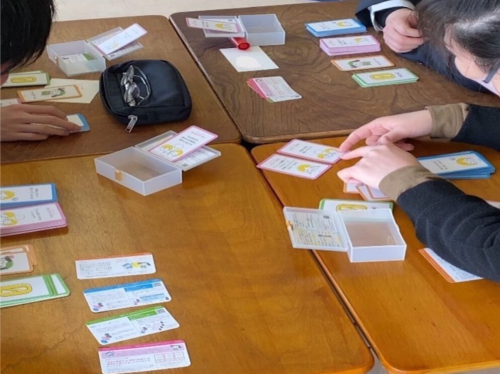 写真:カードゲーム「ココロンリーツナガール」をプレーする高校生たち