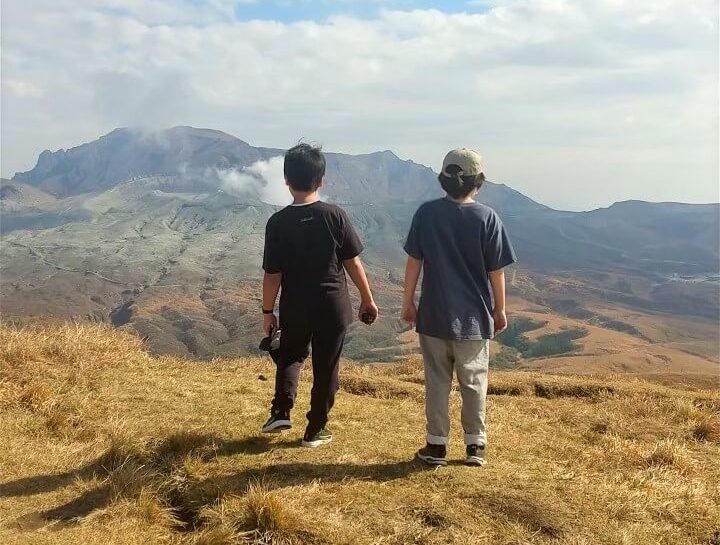 写真：阿蘇山頂に立ち風景を見渡す子どもたち