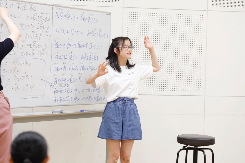 写真:ワークショップで、自ら考えた手歌表現を披露する少女