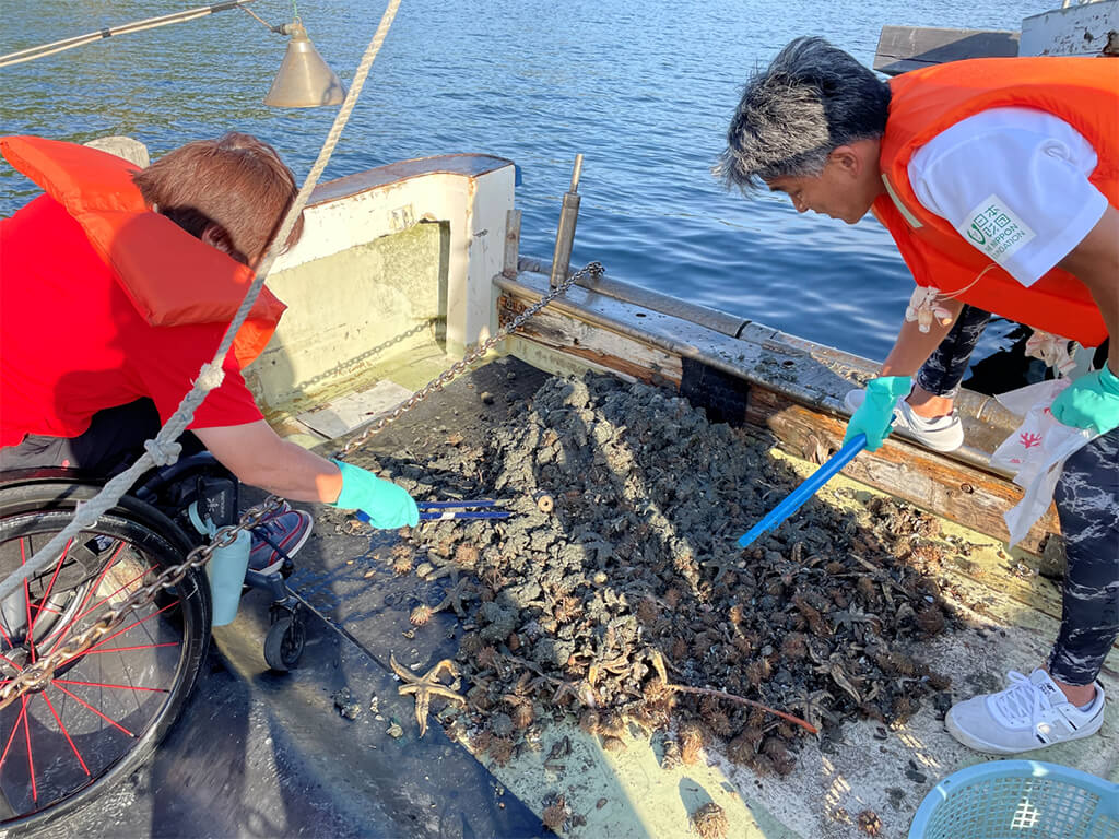 Photo of participants collecting and sorting ocean debris mixed in with fish