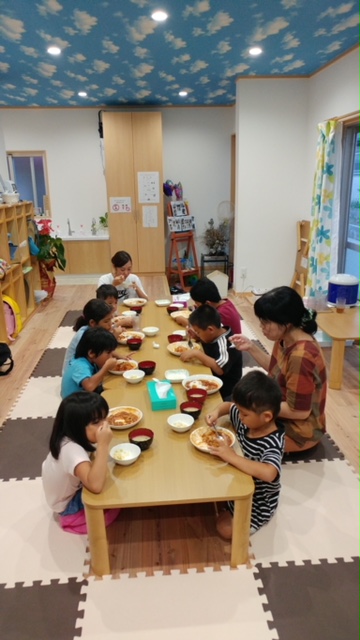 写真:スタッフと子どもたちが一緒に食事をしている様子