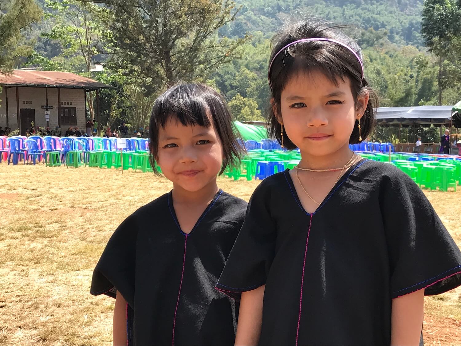 写真:野原に立つ2人のアジア人の子ども