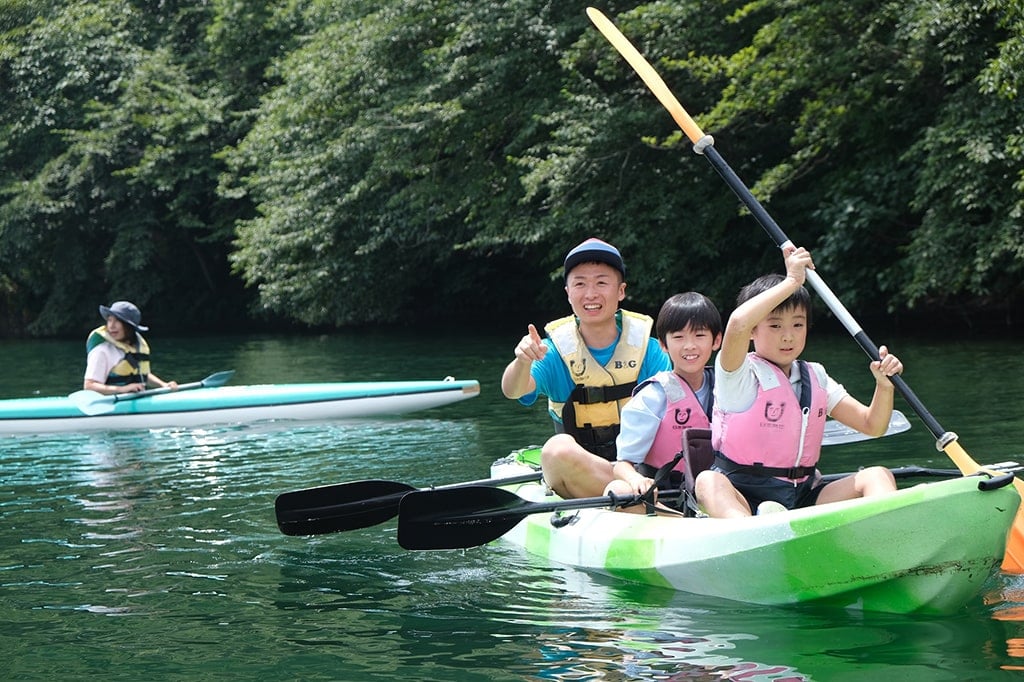 写真:指導員とともにカヌーに乗る子どもたちの様子。