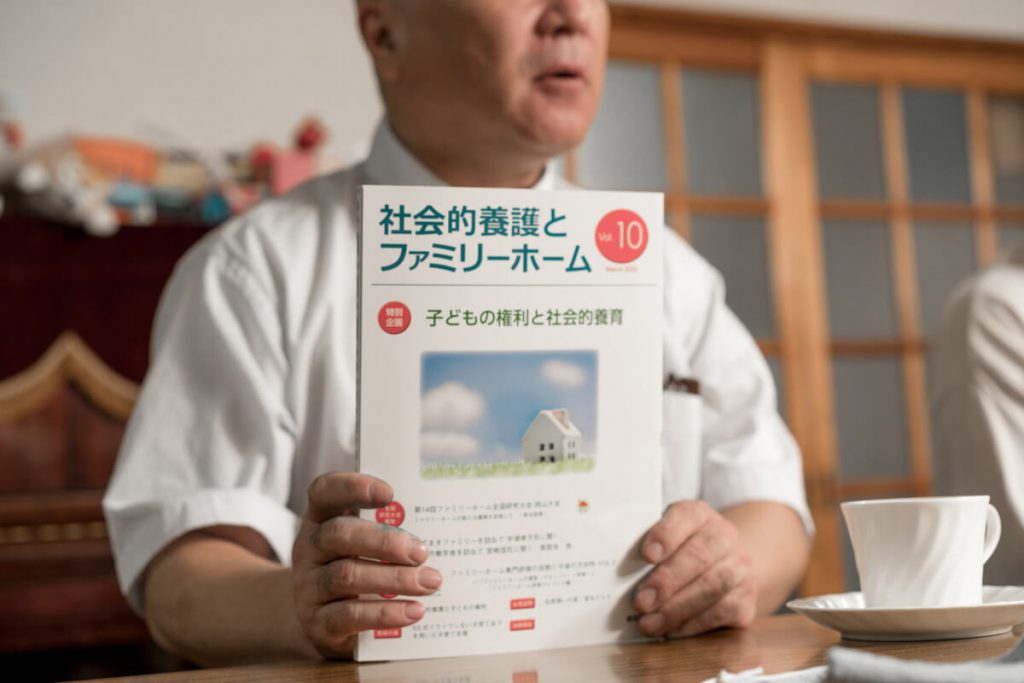 写真:自ら編集する社会的養護とファミリーホームの理解促進を図る冊子を手にする若狭さんの旦那さん