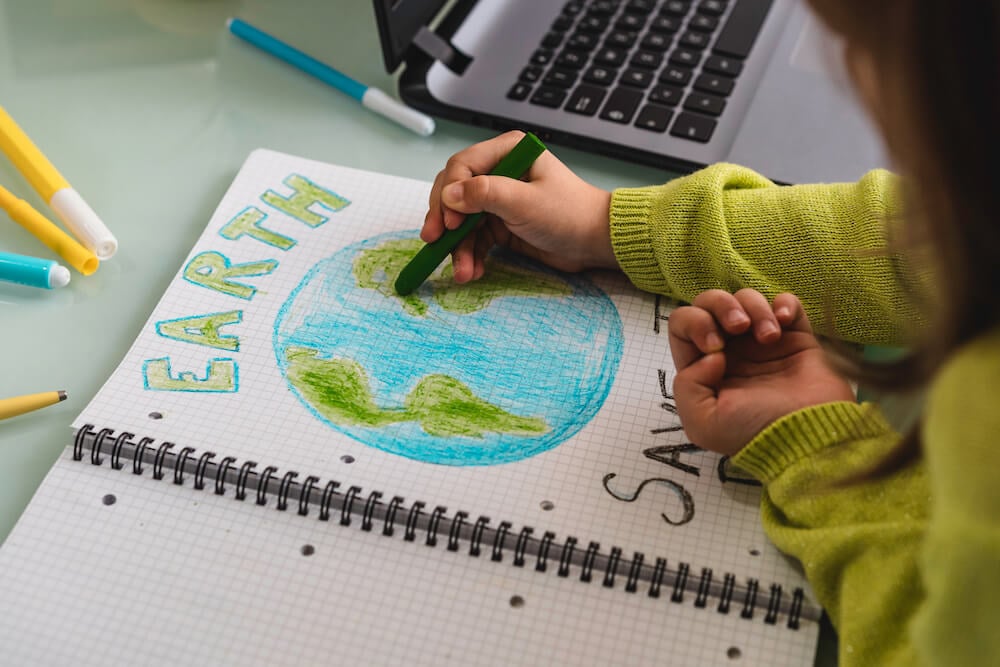 写真:美しい地球の絵を描く子ども(イメージ)
