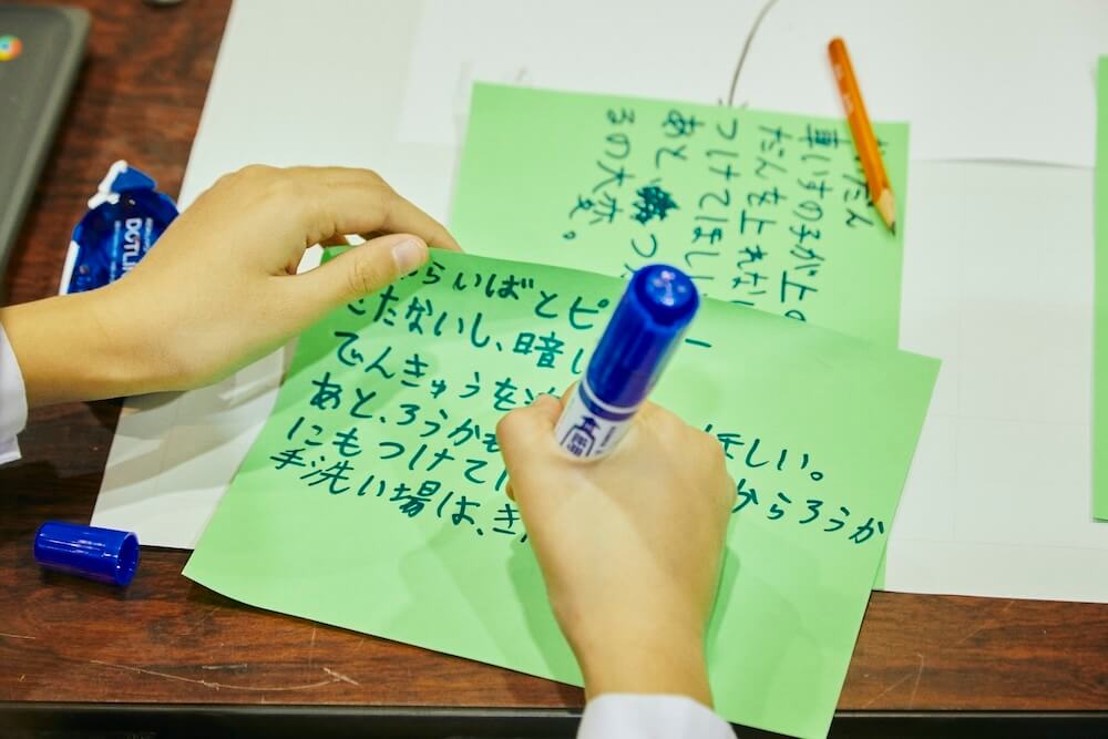 写真:バリアフリー化のアイデアを大きな付箋に書く児童