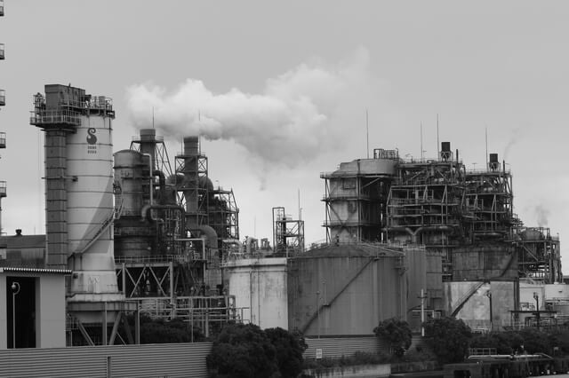 写真(イメージ):煙突から煙を出す工場地帯