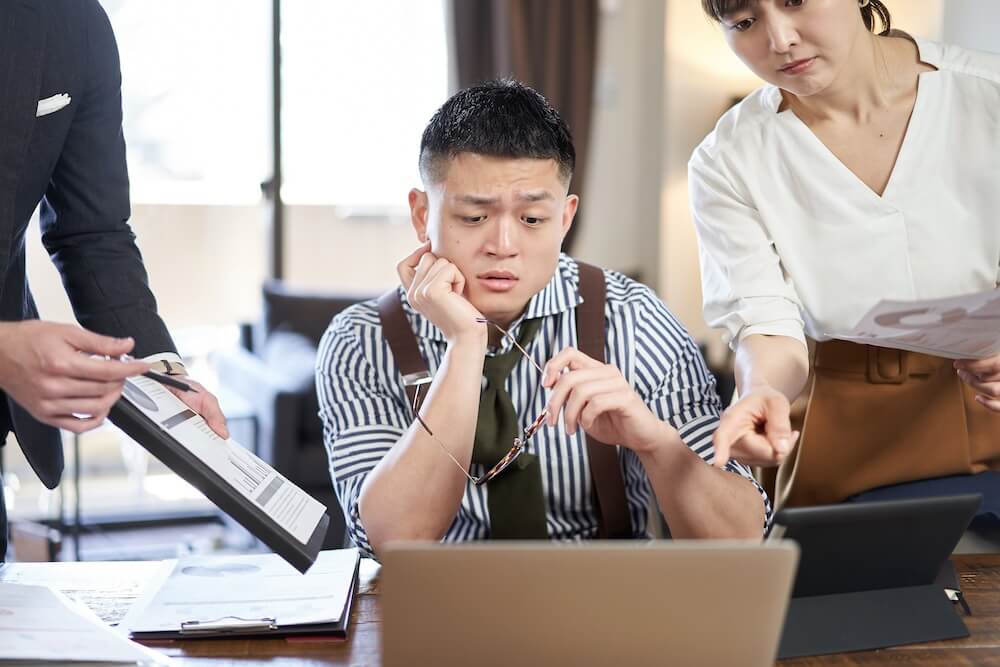 写真(イメージ):職場で同僚から指示をされるなど、プレッシャーを与えられている男性