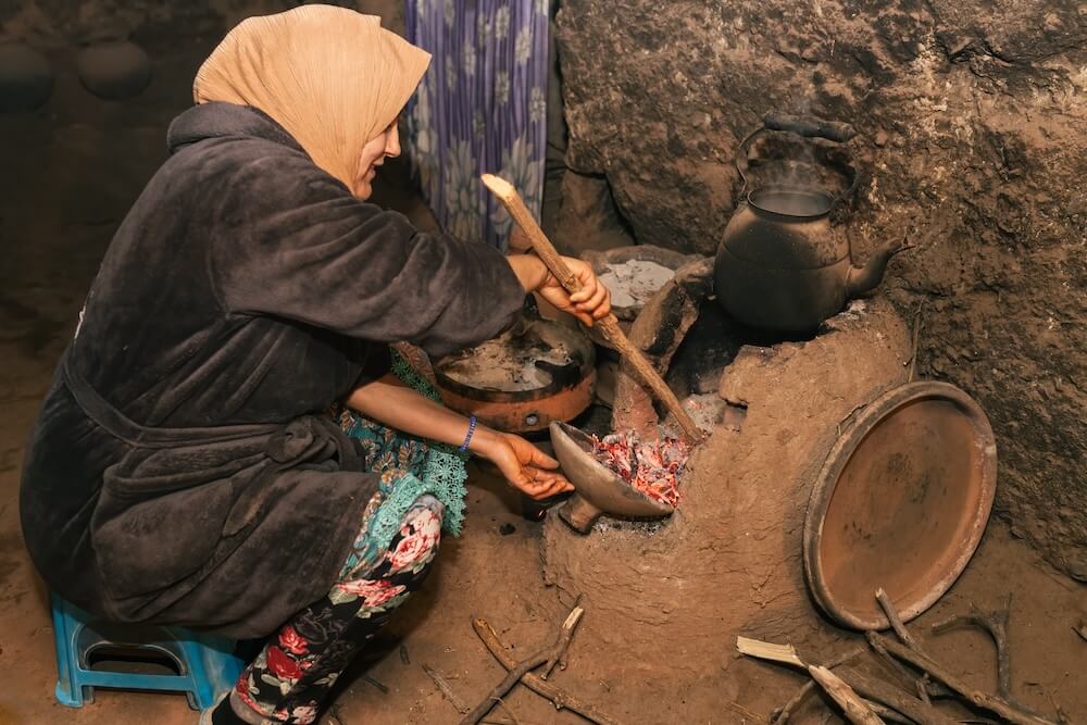 写真:家の中で炭を使って調理する女性