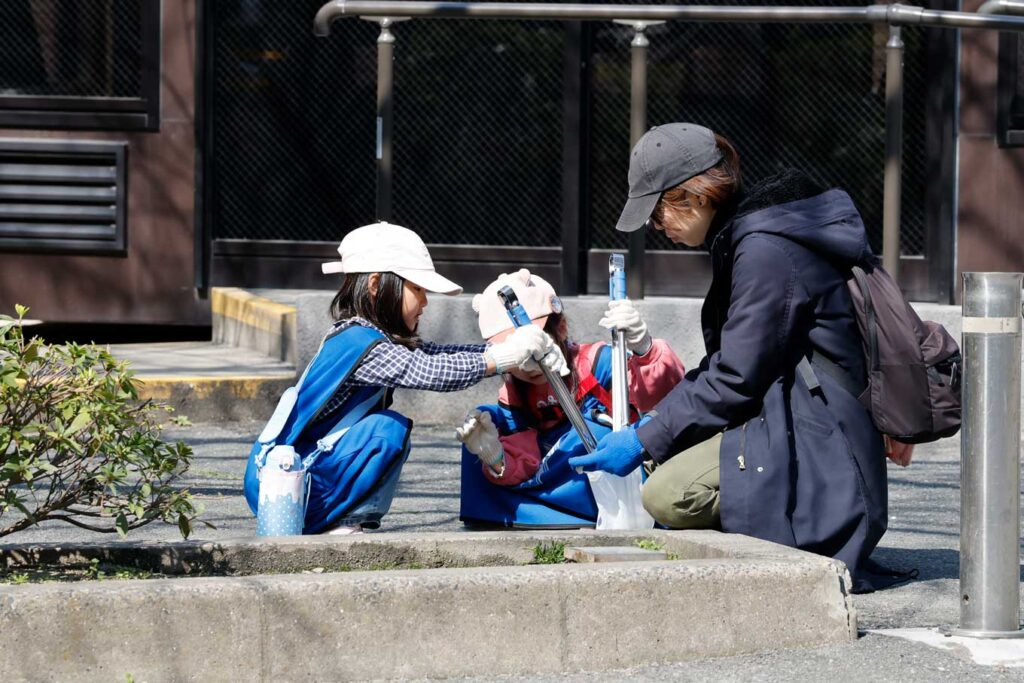 写真:SPOGOMI WORLDCUP エキシビションマッチ参加者の集合写真。画面前側に集められた大量のゴミがある。