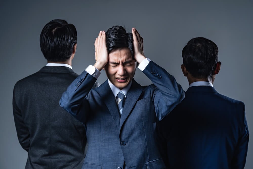 イメージ:部下に間を挟まれ、頭を抱える上司
