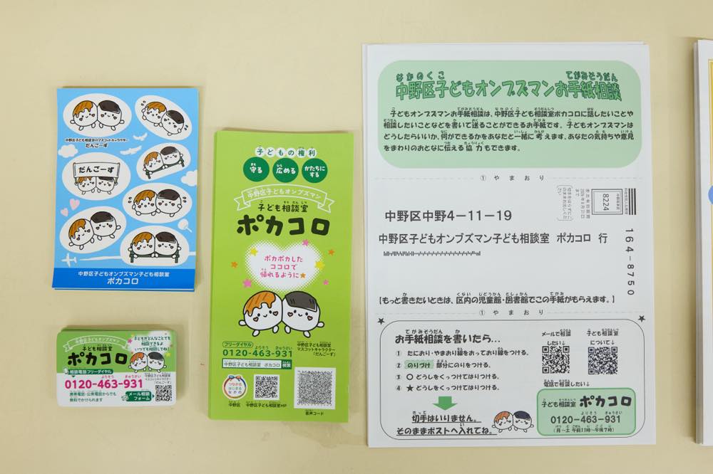子どもたちに配布している、子ども相談室「ポカコロ」のシール、電話番号(0120-463-931)が記されたマグネット、資料と「中野区子どもオンブズマンお手紙相談」と記された相談用紙
