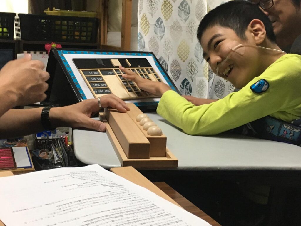 写真：教材を使って楽しそうに学習をしている子どもの様子。