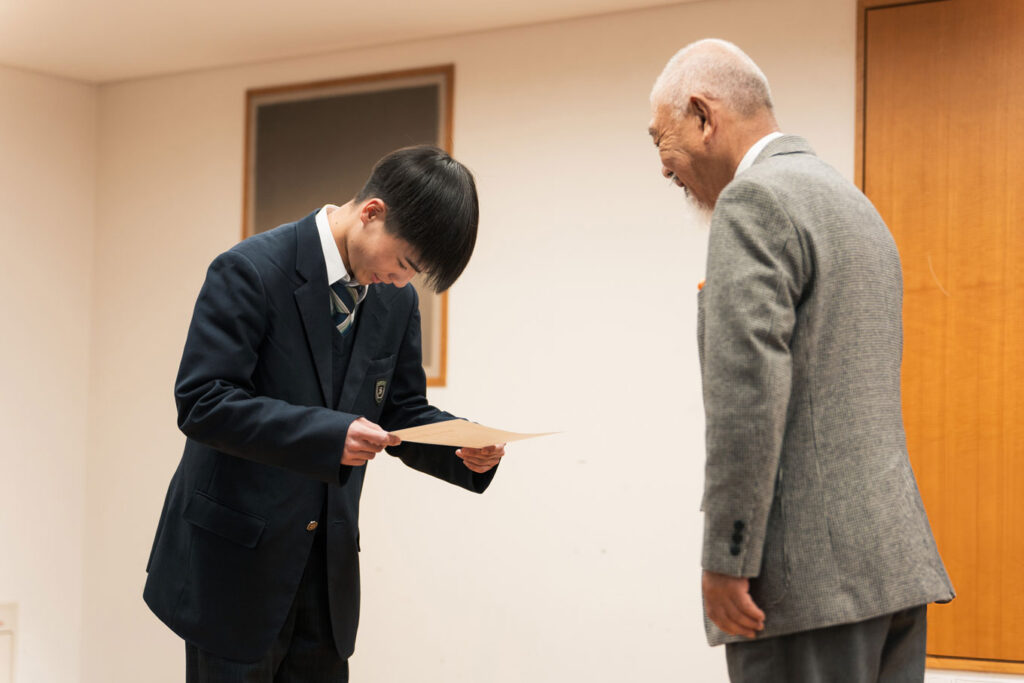 写真：笹川会長より認定証を授与される奨学生