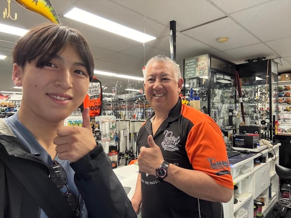 釣具屋で店主と一緒に写る山本詩さん