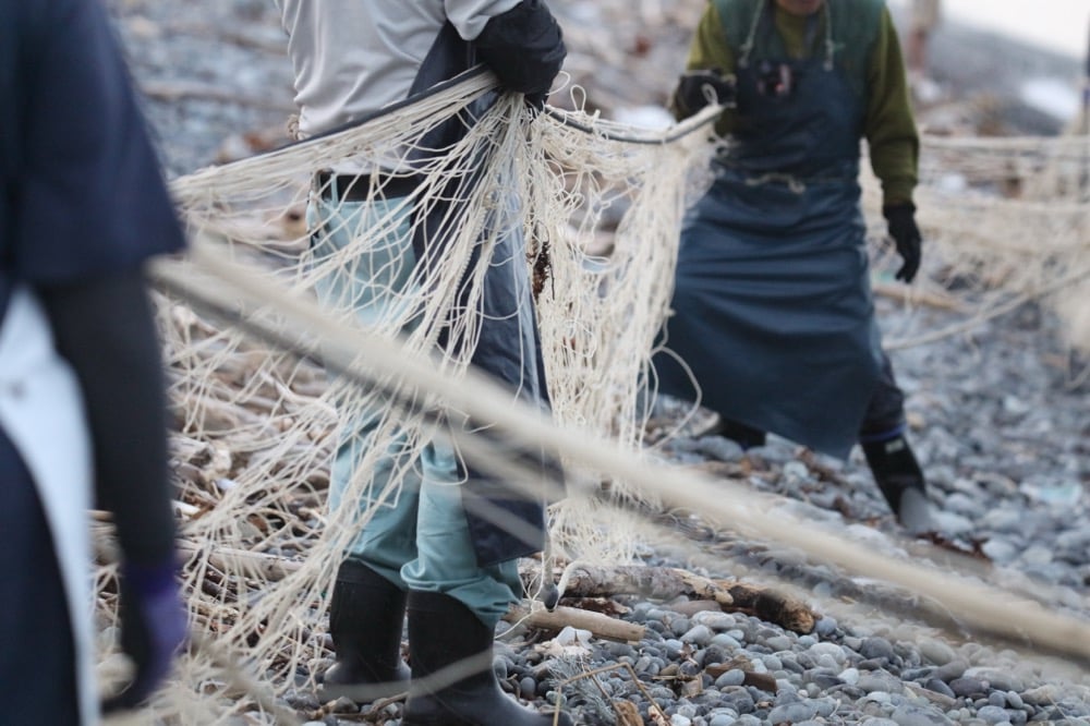 漁師たちが空の漁網を引き揚げている様子