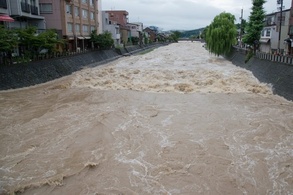 大雨で氾濫目前の川