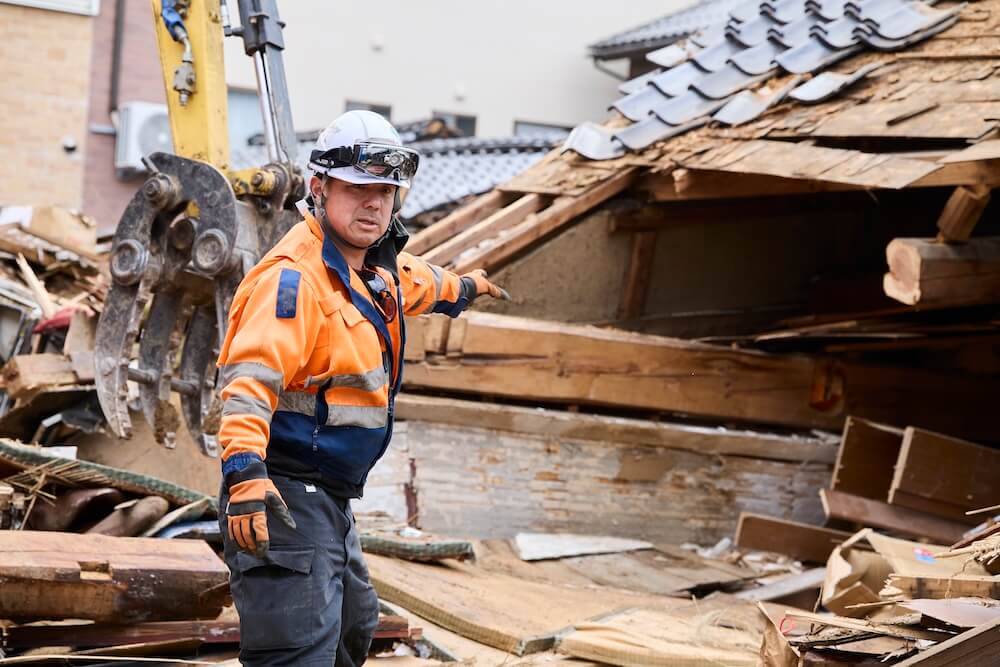 写真：倒壊した家屋をはじめ町の被災状況を説明してくれる吉村さん